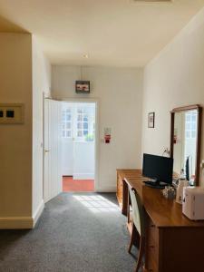 an office with a desk with a computer and a mirror at The Coach and Horses in Winchester