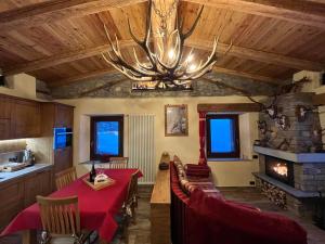 a dining room with a table and a chandelier at Chalet Chez Louis - Alpine Charm with Mont Blanc View & Ski Access in Courmayeur