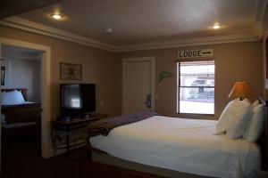 een hotelkamer met een groot bed en een televisie bij The Lodge on Route 66 in Williams