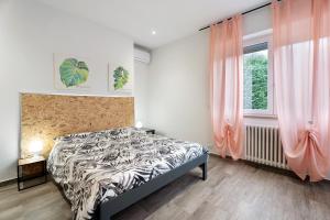 um quarto com uma cama e uma janela com cortinas cor-de-rosa em Il Peperoncino - Arona em Arona