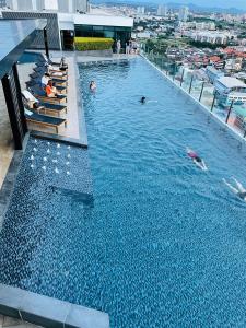 The base Central Pattaya 2 bed 1 bath by Numam في باتايا سنترال: مسبح فوق مبنى فيه ناس