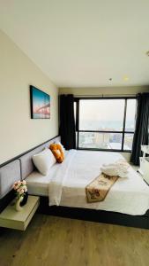 The base Central Pattaya 2 bed 1 bath by Numam في باتايا سنترال: غرفة نوم بسريرين ونافذة كبيرة