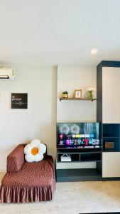 The base Central Pattaya 2 bed 1 bath by Numam في باتايا سنترال: غرفة بسرير وتلفزيون بشاشة مسطحة