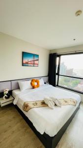 The base Central Pattaya 2 bed 1 bath by Numam في باتايا سنترال: غرفة نوم بسرير كبير عليها دبدوب