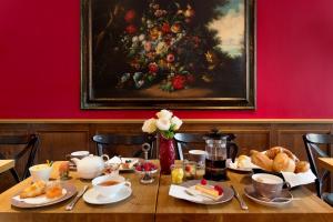 une table avec de la nourriture et une peinture sur le mur dans l'établissement Hotel im Hof, à Munich