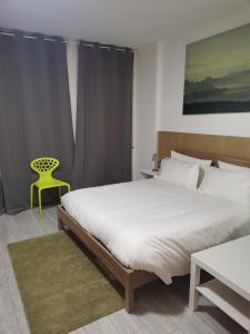 a bedroom with a large bed and a yellow chair at MILANFORESTER in Milan