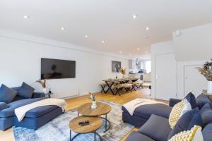 een woonkamer met blauwe banken en een tafel bij Luxury 5 Bedroom House By The Sea in Brighton & Hove