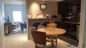 a kitchen and dining room with a table and chairs at Center Suiço Flats in Campos do Jordão