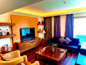 ein Wohnzimmer mit einem Sofa und einem TV in der Unterkunft King Suites Hotel in Beirut