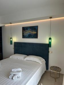 1 dormitorio con 1 cama con 2 toallas en Amani Chic Rooms, en Olbia