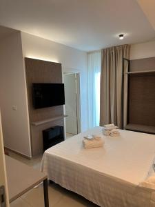 1 dormitorio con 1 cama con 2 toallas en Amani Chic Rooms, en Olbia