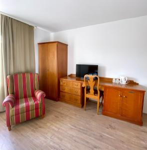 Zimmer mit einem Schreibtisch und einem Stuhl sowie einem Schreibtisch mit einem TV in der Unterkunft Hotel Vienenburg in Goslar