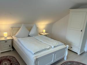 a bedroom with a white bed with two night stands at Casa Avram in Suceviţa