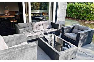 a patio with a couch and chairs and a table at COSY Holiday Home in Harderwijk