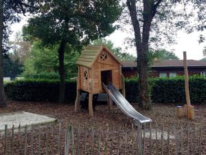 a small playground with a slide and a play house at COSY Holiday Home in Harderwijk