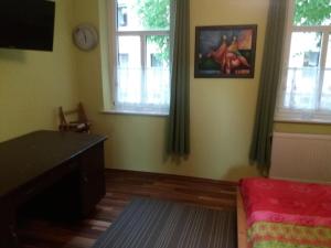 a living room with a desk and two windows at Allsaitig Klang- und Seminarzentrum Selb in Selb