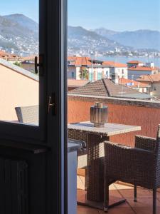 einen Balkon mit Blick auf einen Tisch und Stühle in der Unterkunft APPARTAMENTO CHRISTINA in Baveno