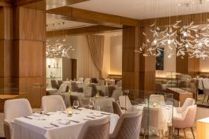 a dining room with white tables and chairs at Le Blanc Spa Resort Cancun - Adults Only - All-Inclusive in Cancún