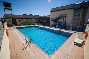 una gran piscina con un tobogán en un edificio en Apartamento EL MIRADOR, recepción 24 h, piscina, wifi y parking interior, en Bormujos