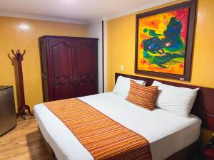 1 dormitorio con 1 cama grande y una pintura en la pared en Hotel Luxor Pereira, en Pereira