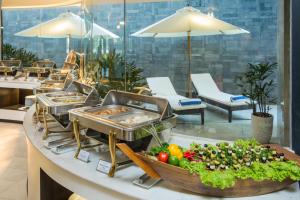 una línea de buffet con frutas y verduras en un mostrador en Satya Da Nang Hotel Han Market, en Da Nang