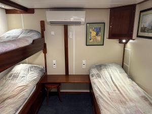 Zimmer mit 2 Etagenbetten und einem Schreibtisch in der Unterkunft Hotelboat Angeline in Amsterdam