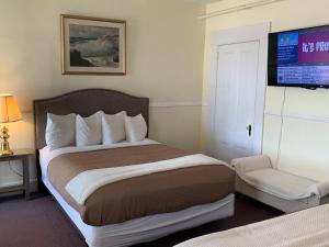 een hotelkamer met een bed en een flatscreen-tv bij Kennedy House in Saint Andrews