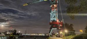 una grande gru seduta sul lato di un fiume di Crane Hotel Faralda ad Amsterdam