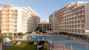 Ukino Palmeiras Village - 24h All Inclusive في أرماساو دي بيرا: اطلالة المنتجع على المسبح والمباني