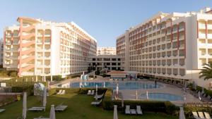 Ukino Palmeiras Village - 24h All Inclusive في أرماساو دي بيرا: منتجع فيه مسبح ومبنيين طويلين