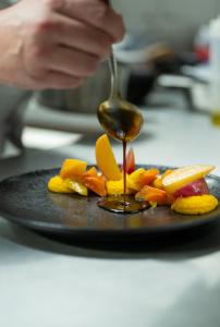 um prato de comida com uma colher de molho em Hôtel-Restaurant du Cerf em Les Ponts-de-Martel