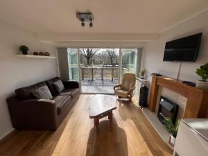 ein Wohnzimmer mit einem Sofa und einem Kamin in der Unterkunft North Wales Lake View 2 Bedroom in Caernarfon