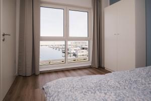 um quarto com uma grande janela com vista para um porto em Fewo Steuerbord em Braunsbedra