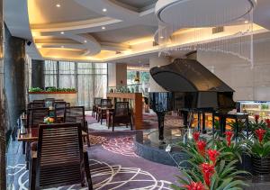 un vestíbulo con piano, mesas y sillas en Yiwu Ocean Hotel - Original Best Western Premier Ocean Hotel, en Yiwu