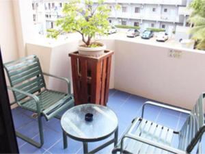 a balcony with a chair and a table and a plant at Holiday Saipan Hotel in Saipan