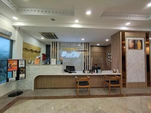 a restaurant with a counter and two chairs in a lobby at Grand City Hotel in Bandar Seri Begawan