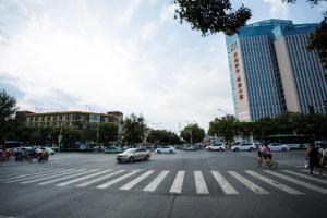 银川IU Hotels·Yinchuan Railway Station的一条繁忙的城市街道,有汽车和人穿过街道