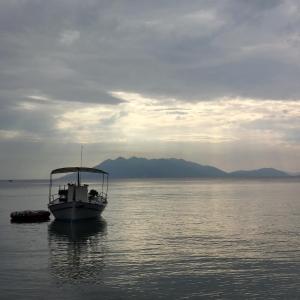 un bateau flottant dans l'eau sur un lac dans l'établissement Mouria Pension Rooms & Studios, à Ancient Epidavros