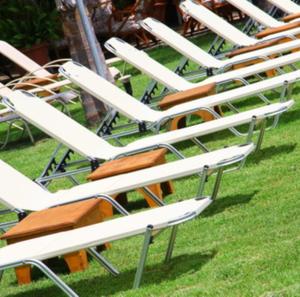 une rangée de chaises de jardin blanches assises sur l'herbe dans l'établissement Mouria Pension Rooms & Studios, à Ancient Epidavros