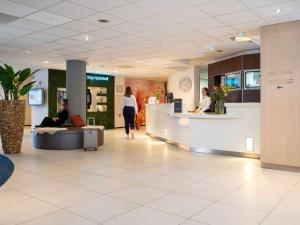 a lobby of a store with people sitting at a counter at Novotel Maastricht in Maastricht