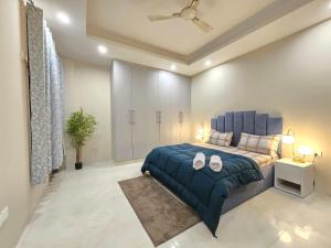 - une chambre avec un lit bleu et une couverture bleue dans l'établissement Homlee-Saket Anupam Stylish 3BHK in South Delhi, à New Delhi