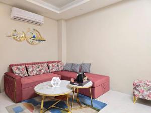 - un salon avec un canapé rouge et une table dans l'établissement Homlee-Saket Anupam Stylish 3BHK in South Delhi, à New Delhi