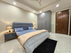 - une chambre avec un lit bleu et une armoire en bois dans l'établissement Homlee-Saket Anupam Stylish 3BHK in South Delhi, à New Delhi