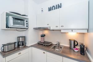 a kitchen with a microwave and a counter top at Möwennest App 18 in Wenningstedt