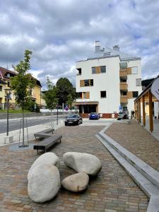 um edifício com três grandes pedras numa calçada de tijolos em Apartmán “U nás v podkroví“ v Rezidenci Klostermann, Železná Ruda 24 em Železná Ruda