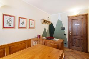 a room with a wooden table and a wooden door at Residence Larice Bianco App n3 in Campodolcino