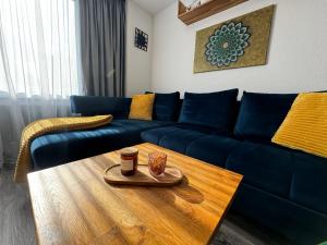 - un salon avec un canapé bleu et une table basse dans l'établissement Apartmán PiccolaDuo v Banskej Bystrici, à Banská Bystrica