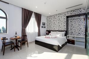 A bed or beds in a room at Dylan Hotel Danang