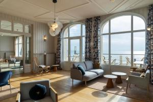 een woonkamer met meubilair en grote ramen bij Hôtel Morgat Le Grand Hôtel De La Mer in Crozon