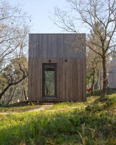 a small wooden house on a hill with trees at Refugio do Carrascal in Tomar